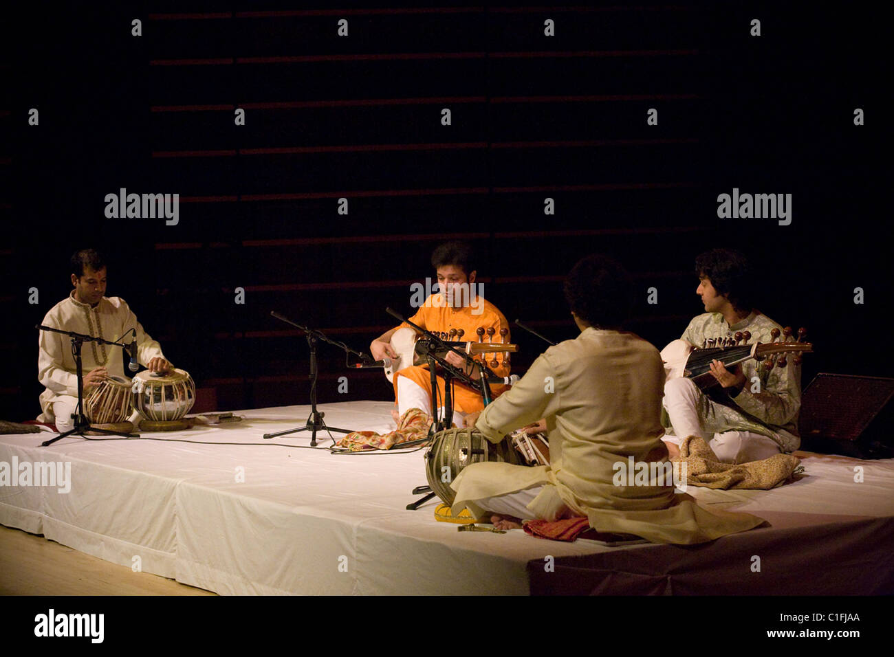 Classical Indian musicians perform onstage including famous sarod