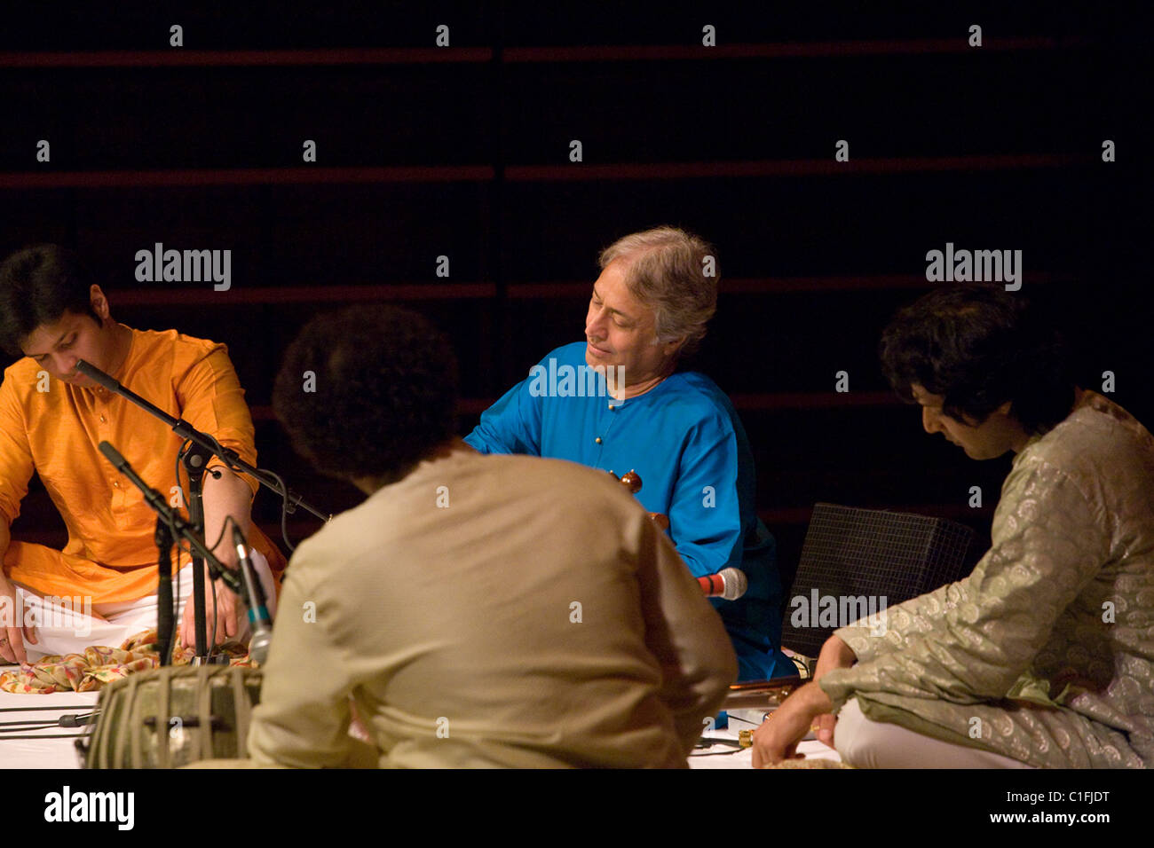 Classical Indian musicians perform onstage including famous sarod