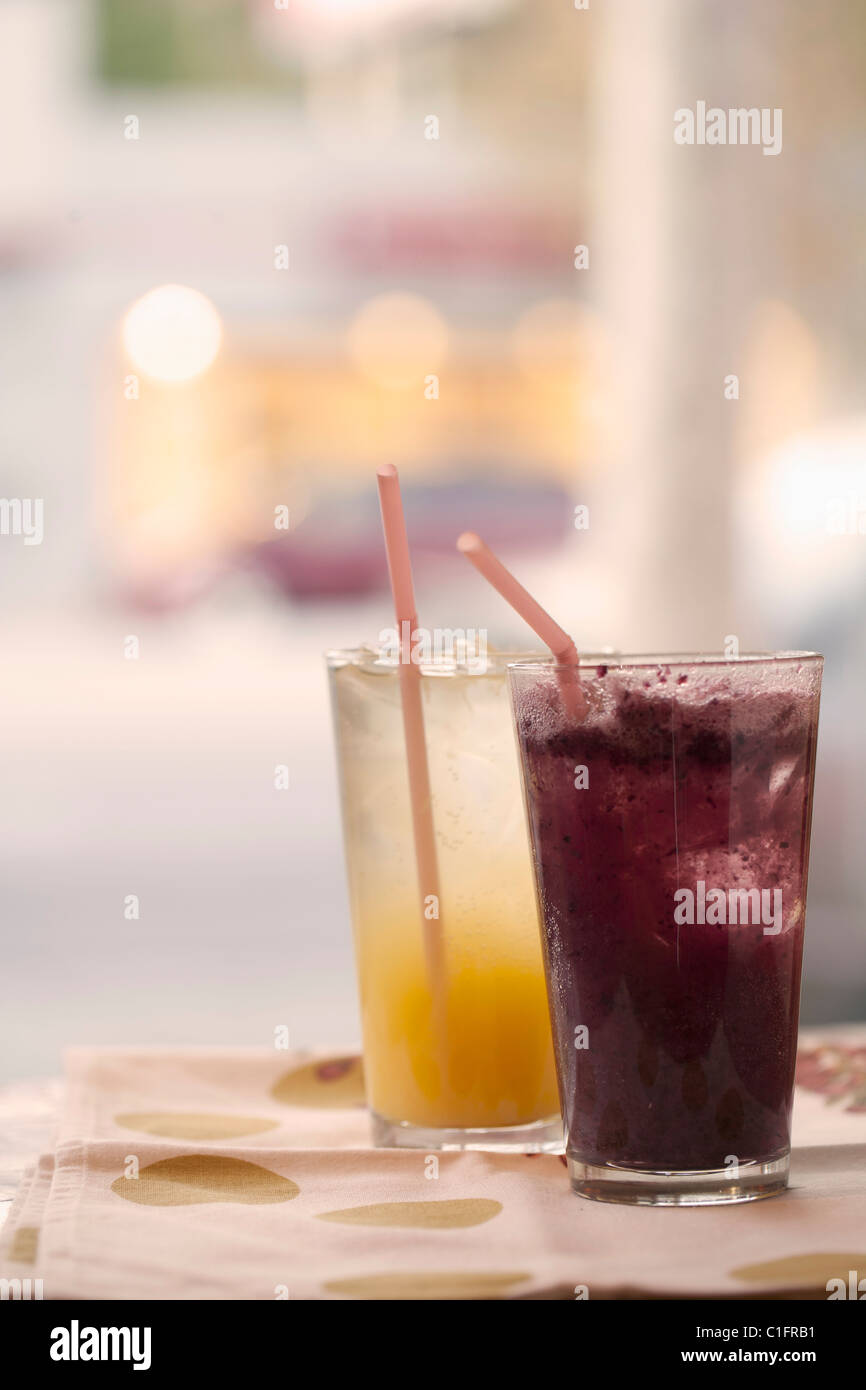 Orange and grape juice in glasses with straws Stock Photo - Alamy