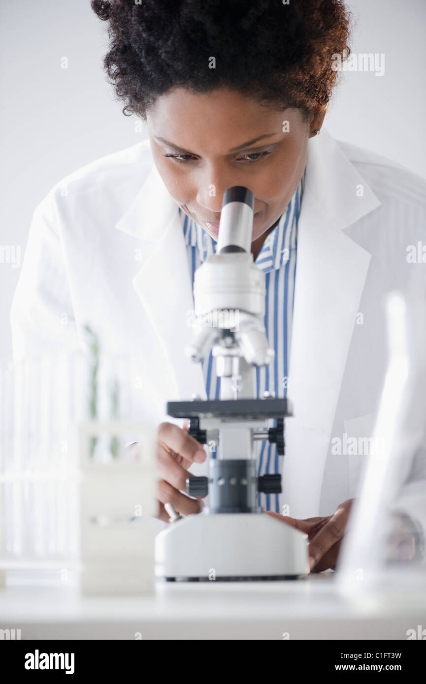 Black scientist looking into microscope Stock Photo Alamy
