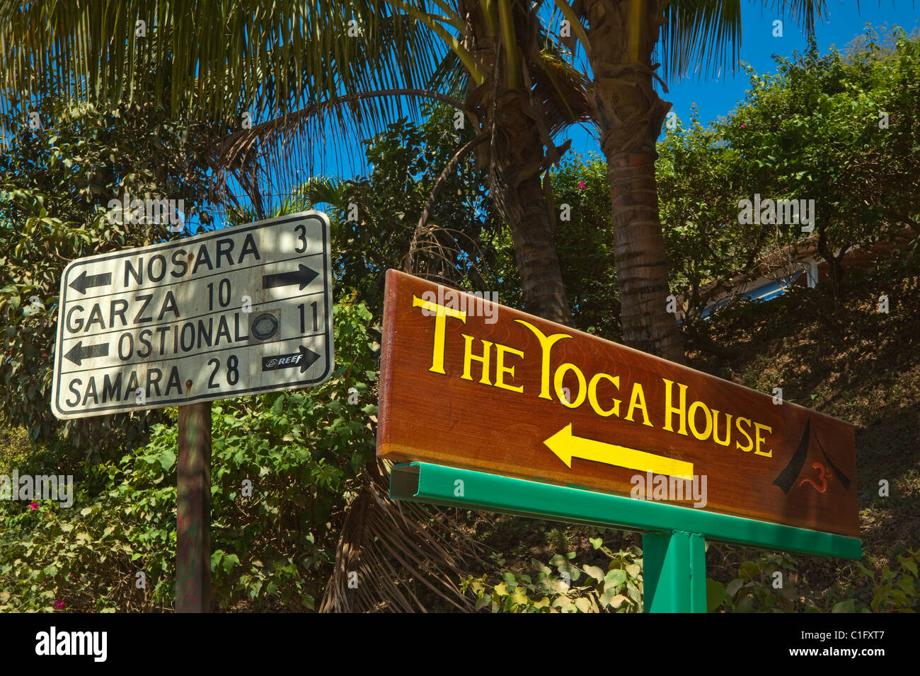 Road and Yoga House sign at this laid-back expatriate green zone surf community & major centre for yoga, Nosara, Costa Rica Stock Photo