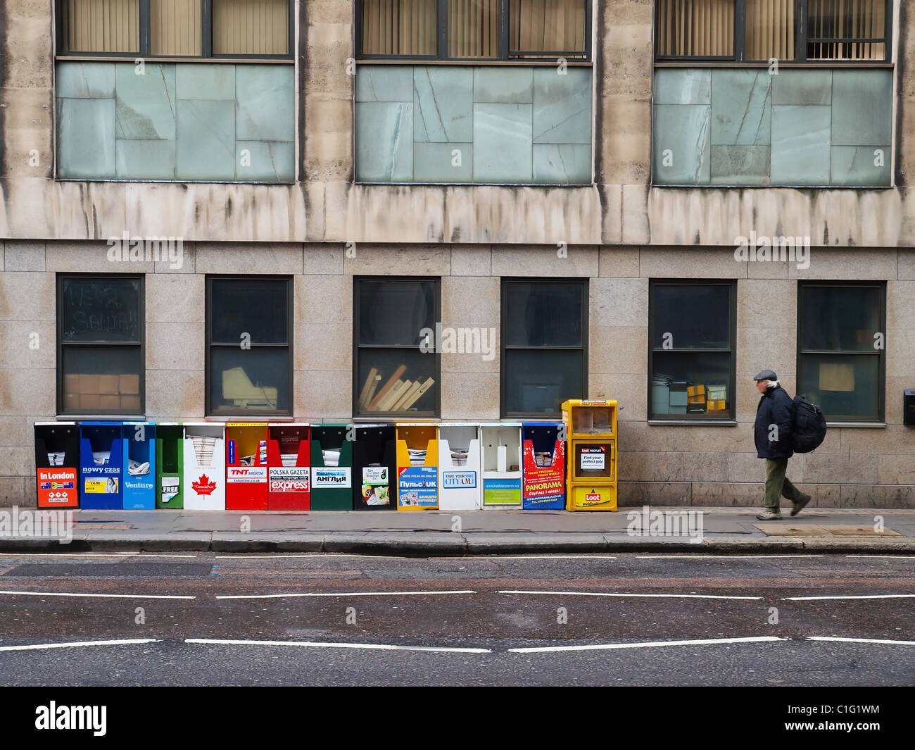 A man walks past the many international newspapers on sale in London. Stock Photo