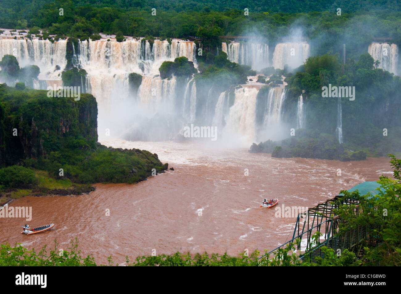 Tourists view Iguazu Falls, one of the world's most famous natural wonders, located at the border of Brazil and Argentina. Stock Photo