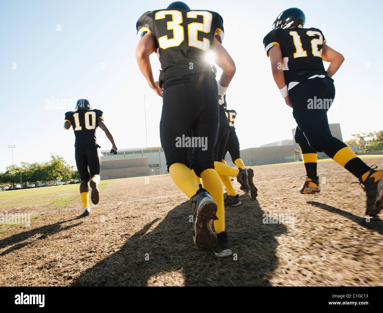 Football players running on football field Stock Photo Alamy