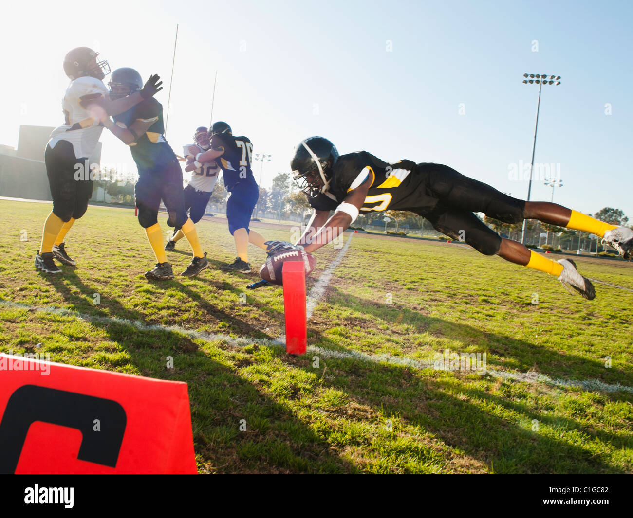 Football player scoring goal on football field Stock Photo