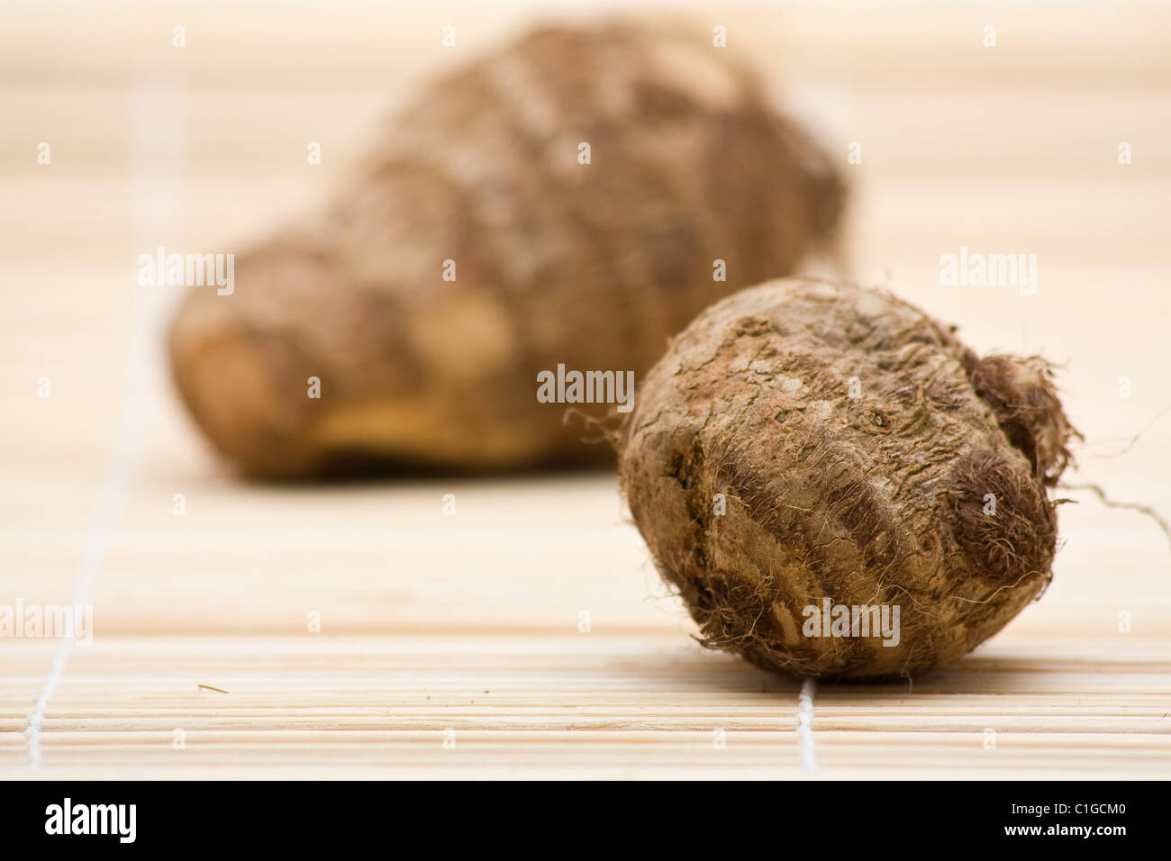 Fresh whole taro root on bamboo mat Stock Photo