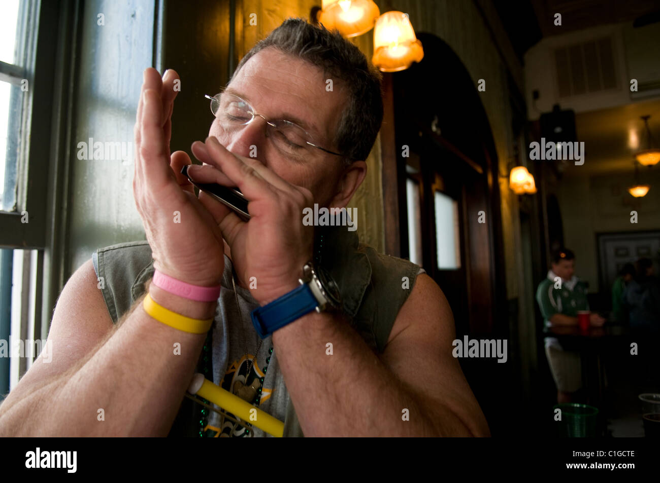 Portrait of a man playing the harmonica inside of a bar during Savannah