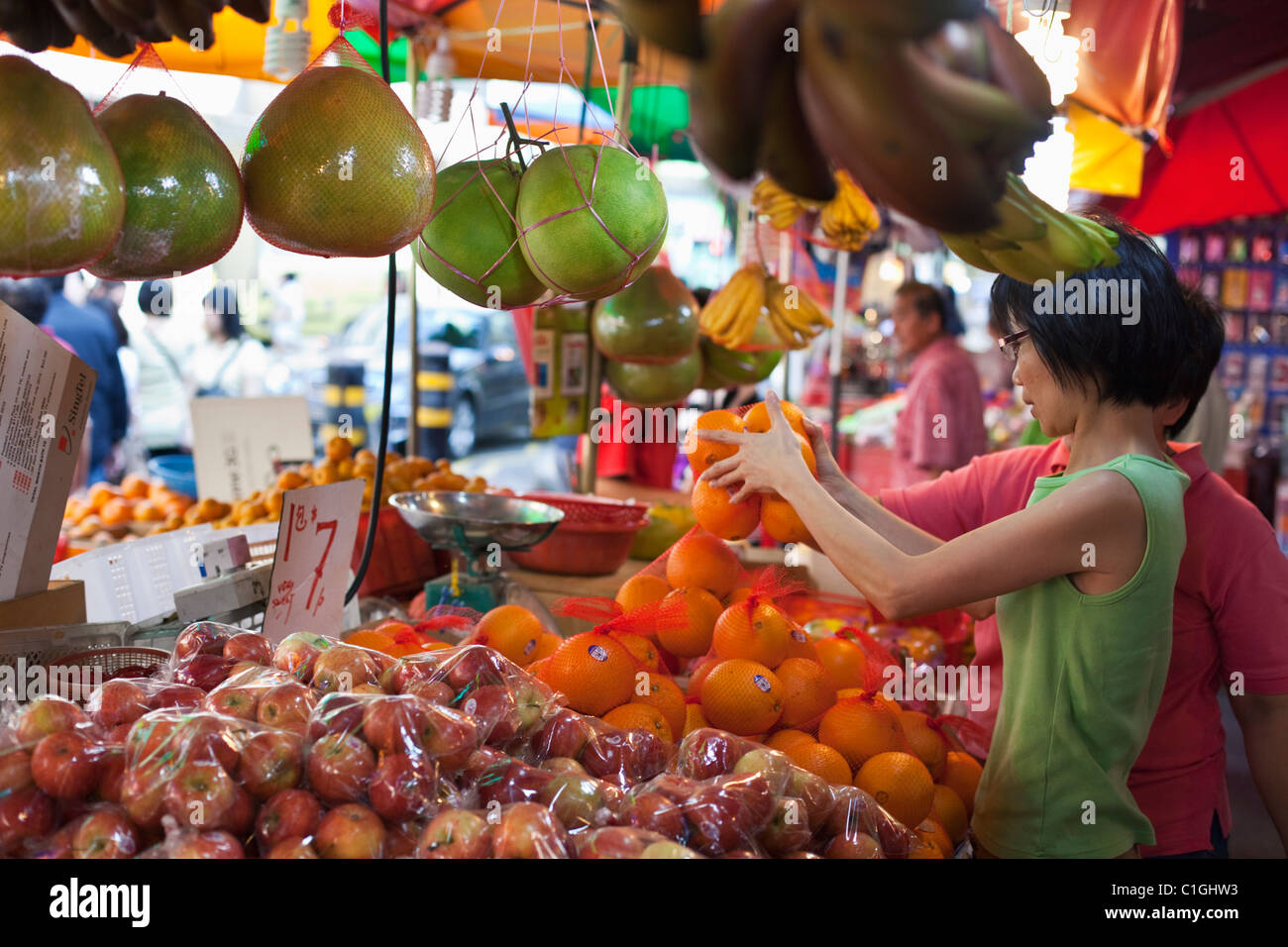 Woman shopping for fruit at Bugis Street Market.  Bugis, Singapore Stock Photo