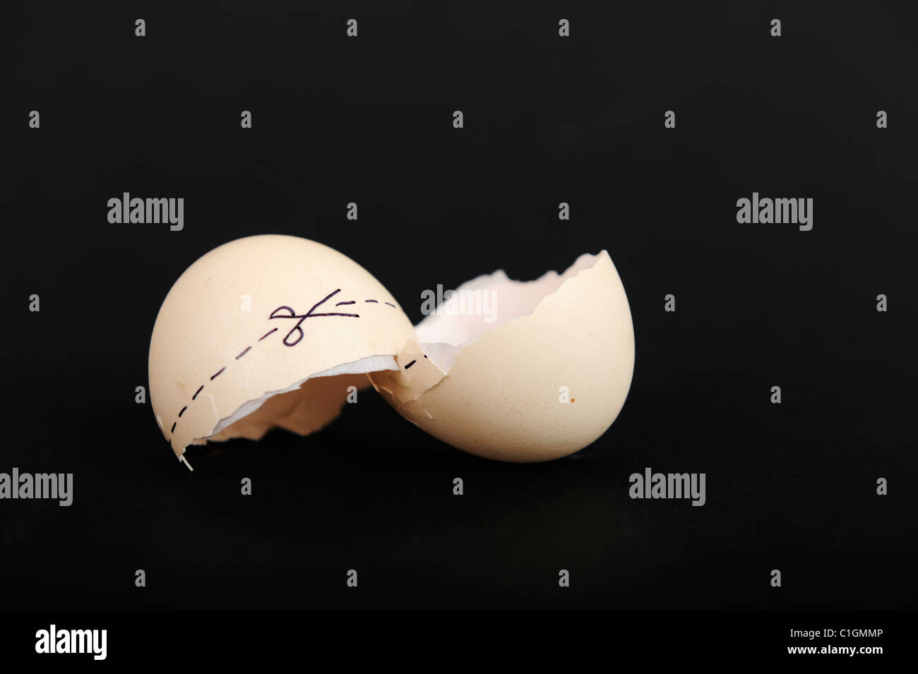 Stock photo of cracked egg shells with a cut here mark across the shell. Stock Photo
