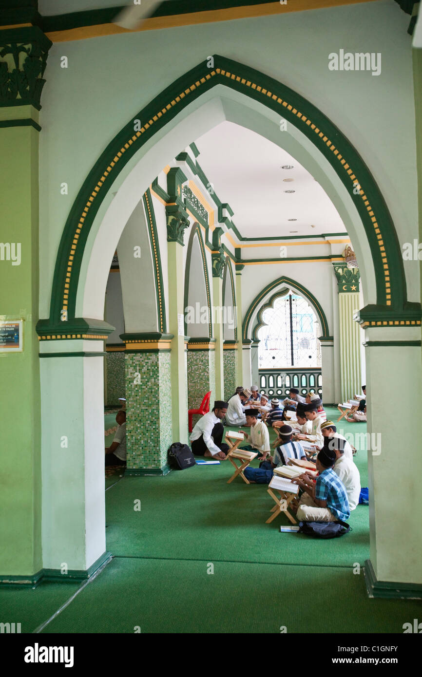 Young boys studying the Qur'an in the Abdul Gaffoor Mosque.  Little India, Singapore Stock Photo