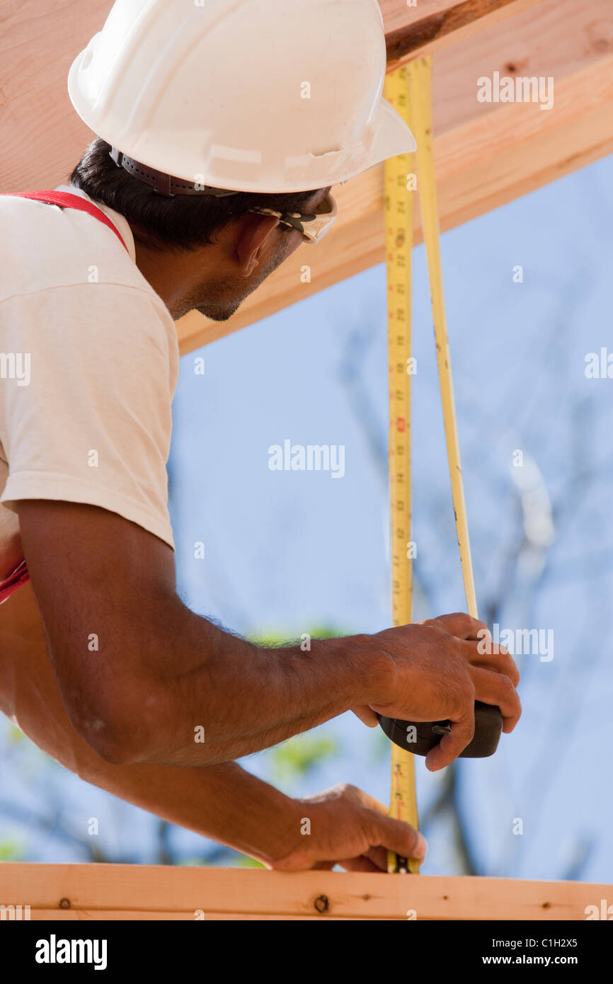 Carpenter measuring a wooden beam Stock Photo - Alamy
