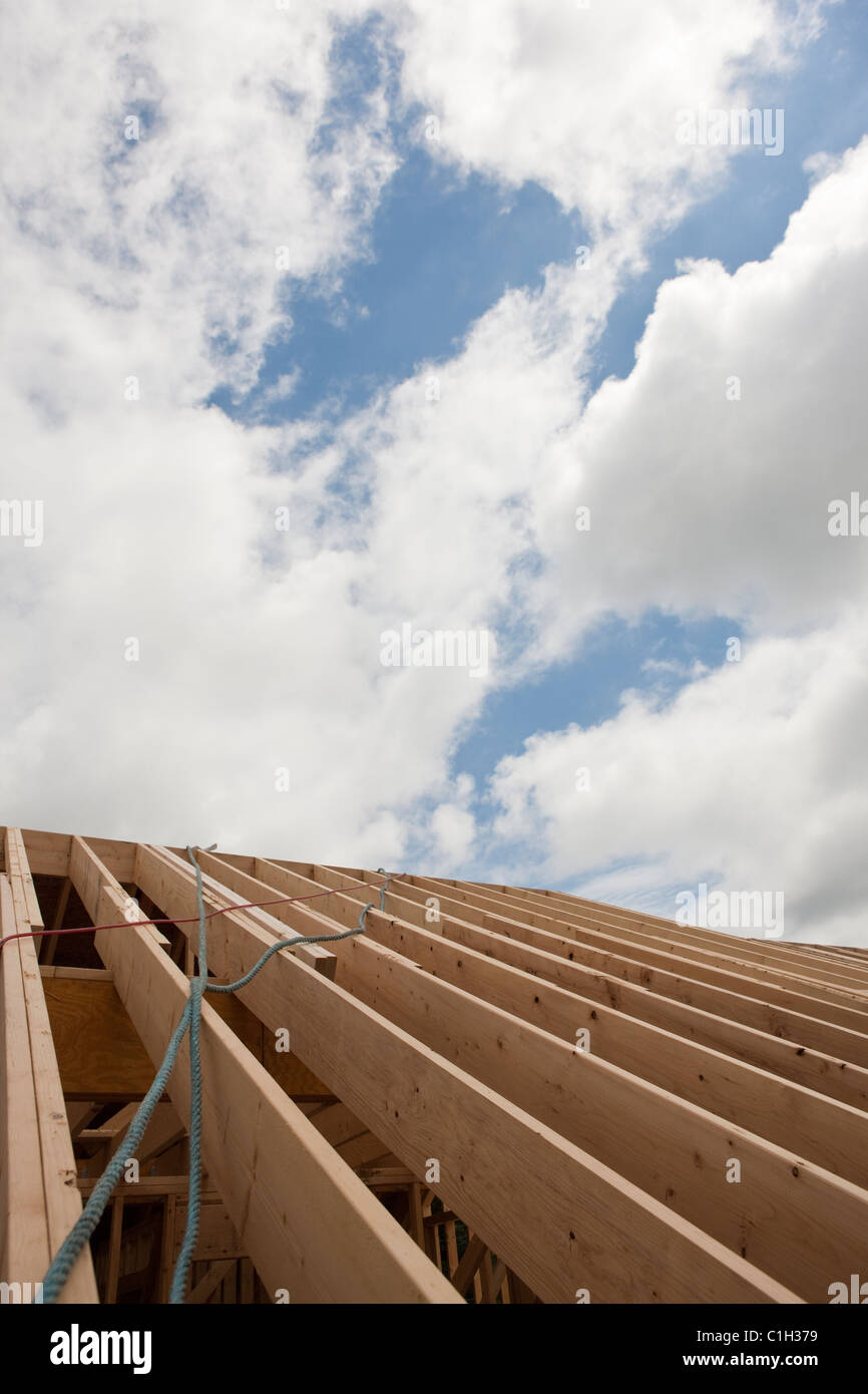 Safety ropes hanging from roof trusses at a house under construction Stock Photo