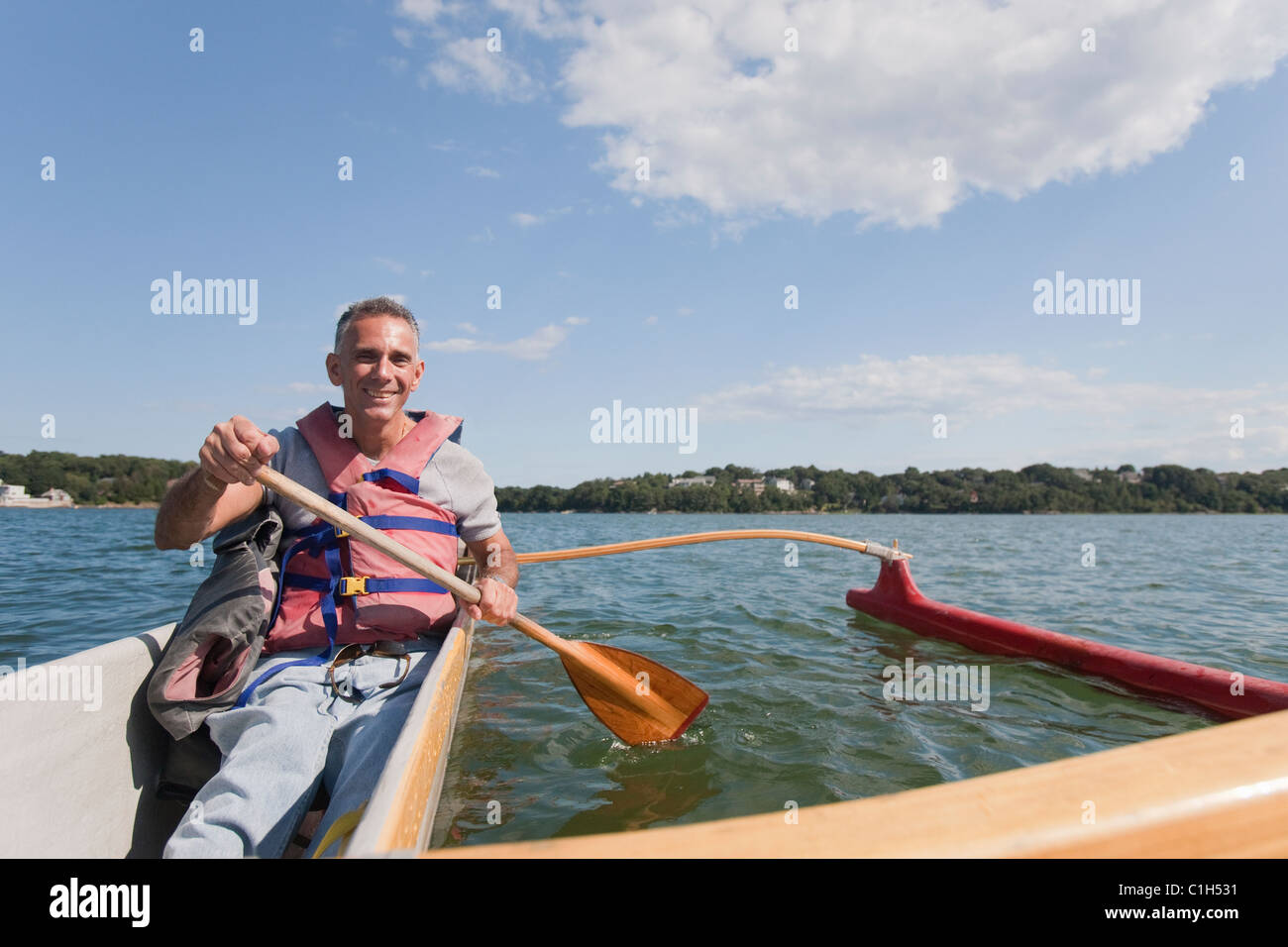 Man with spinal cord injury outrigger canoeing in the sea Stock Photo