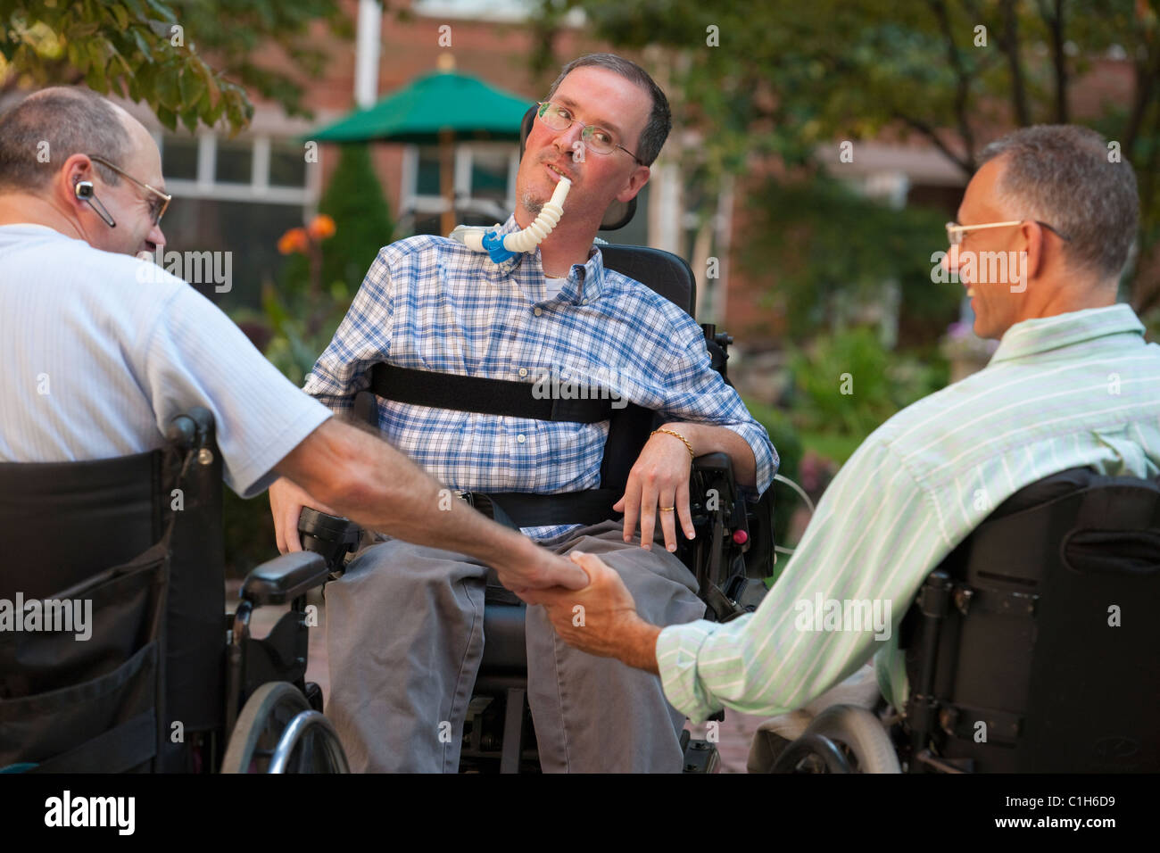 Three men in wheelchairs greeting each other Stock Photo Alamy