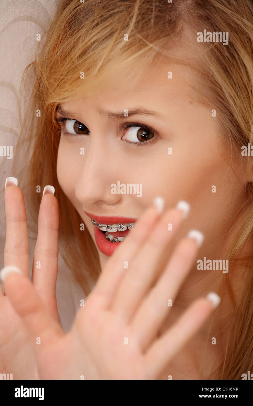 Abused young woman trying to hide and defend herself Stock Photo