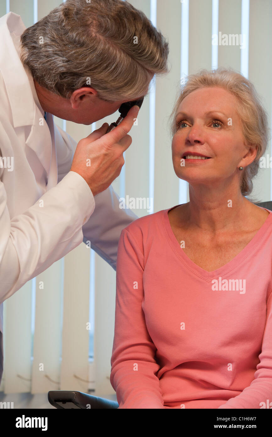 Ophthalmologist examining a woman's eyes with a direct ophthalmoscope