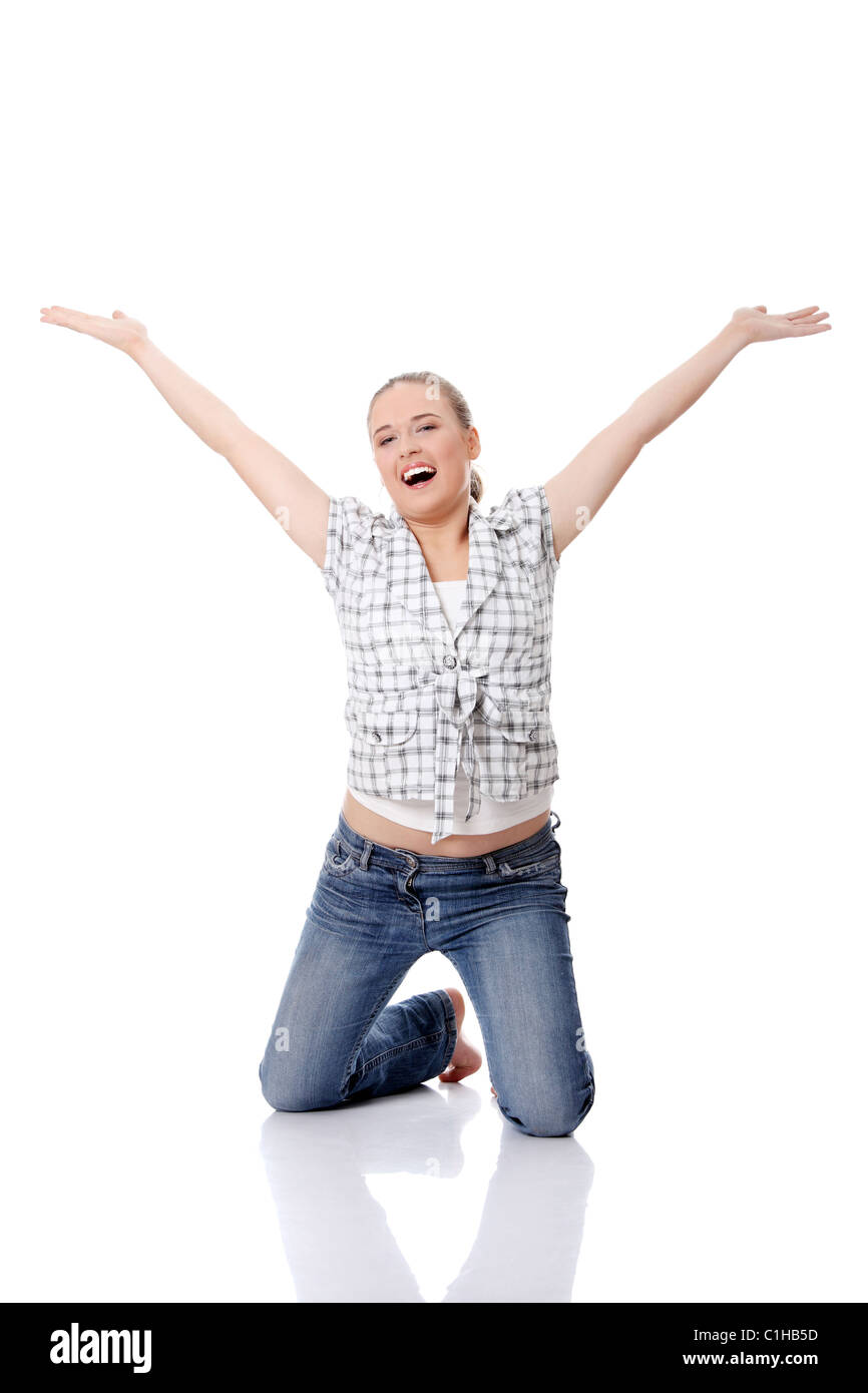 Young happy woman on knees, with hands up, isolated on white Stock Photo