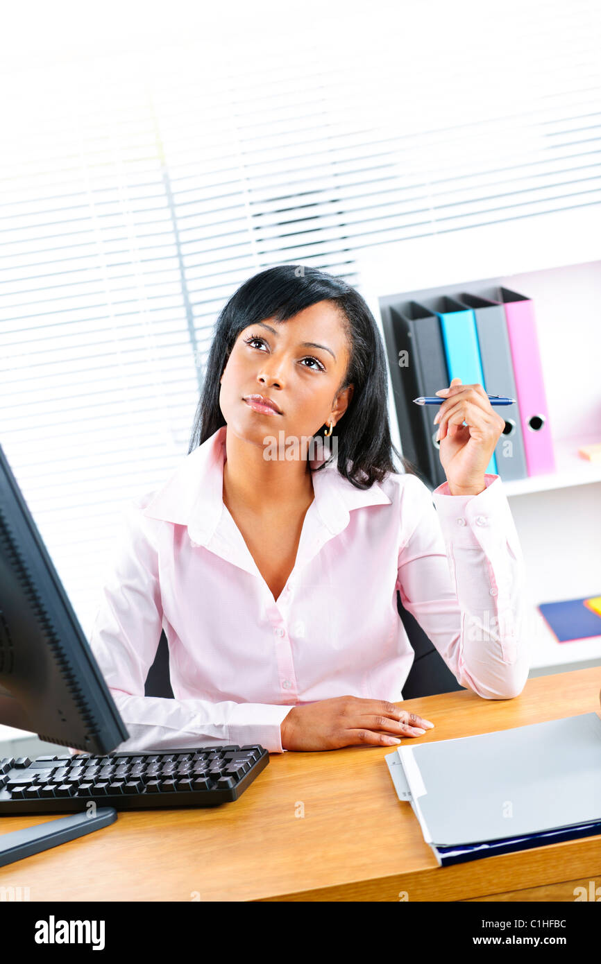 Young black business woman thinking at desk in office Stock Photo - Alamy