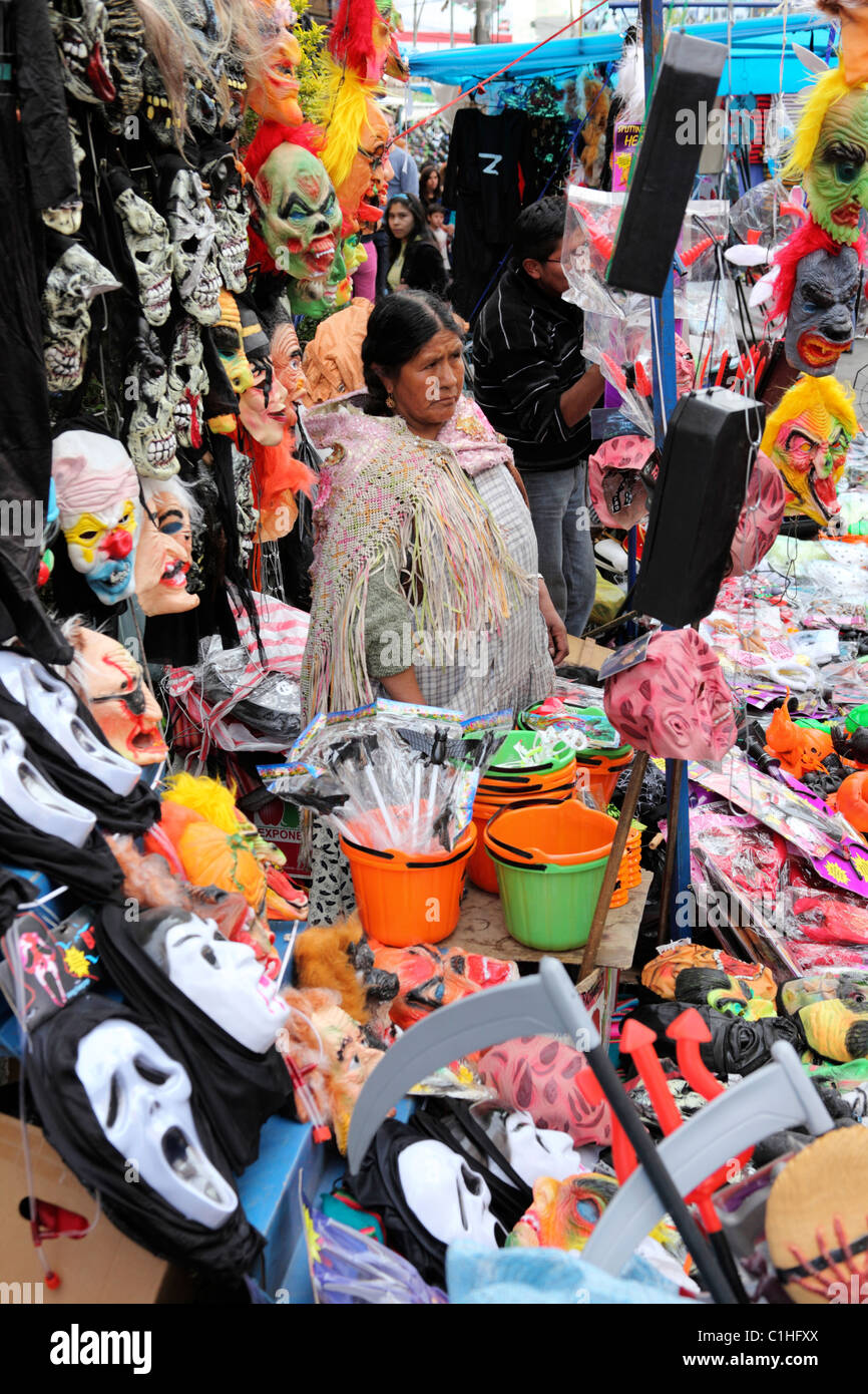 Aymara woman selling masks (including GhostFace masks from the Scream movies), costumes and items for Halloween in street market, La Paz, Bolivia Stock Photo