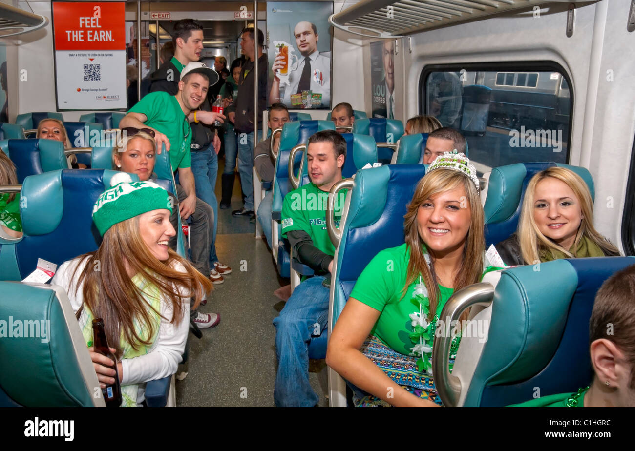 MARCH 17 2011 - LONG ISLAND NY: Happy young passengers riding in Long Island Railroad train LIRR to Manhattan, St. Patrick's Day Stock Photo