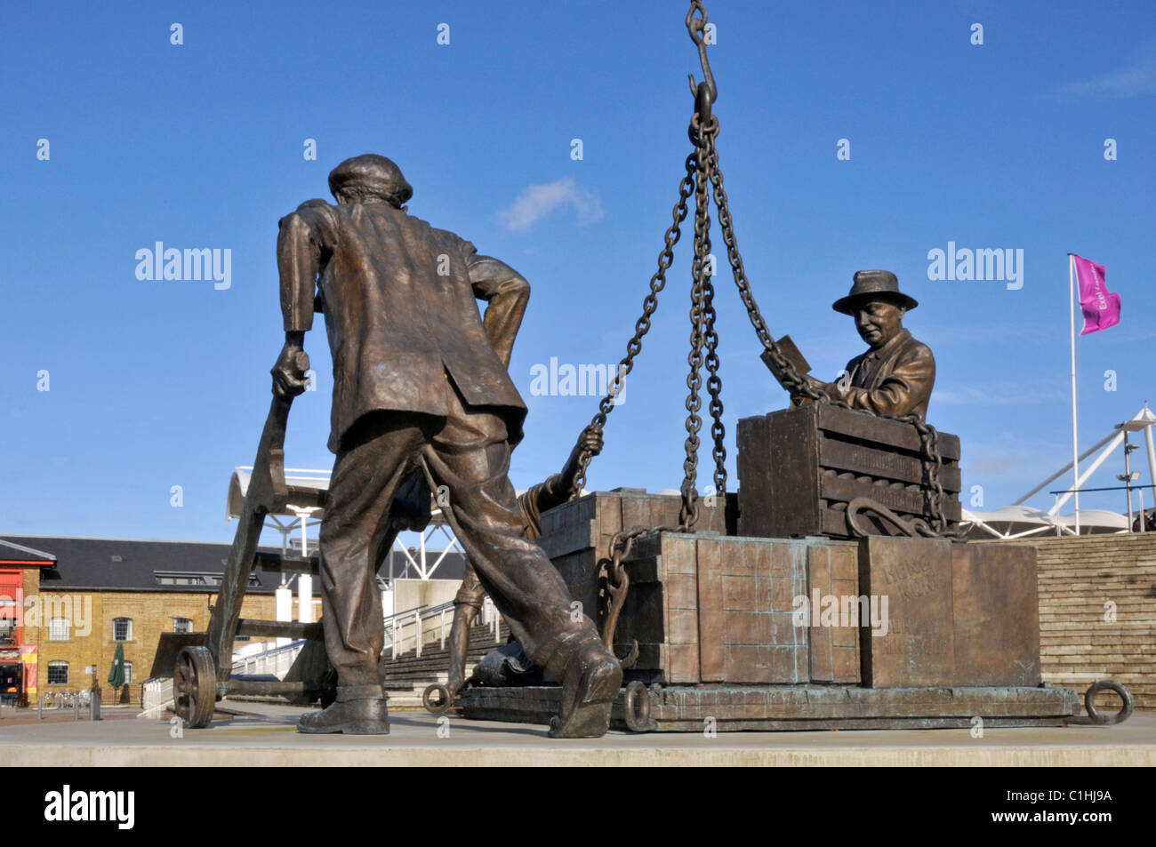 Historical tribute sculpture statue dockers working outside Excel Exhibition Centre London Docklands entitled Landed by sculptor Les Johnson Newham UK Stock Photo