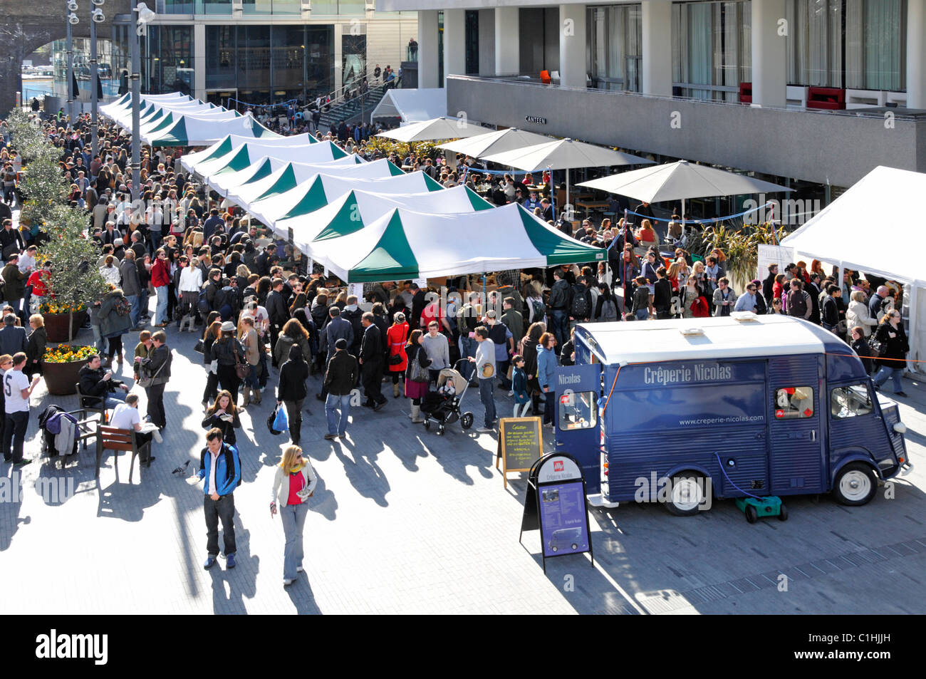 London street scene view from above looking down on crowds of people at Royal Festival Hall forecourt being used for a weekend food market England UK Stock Photo