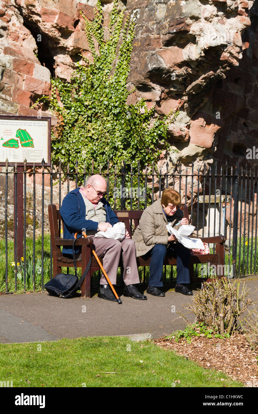 Elderly couple eating fish and chips on a bench Stock Photo