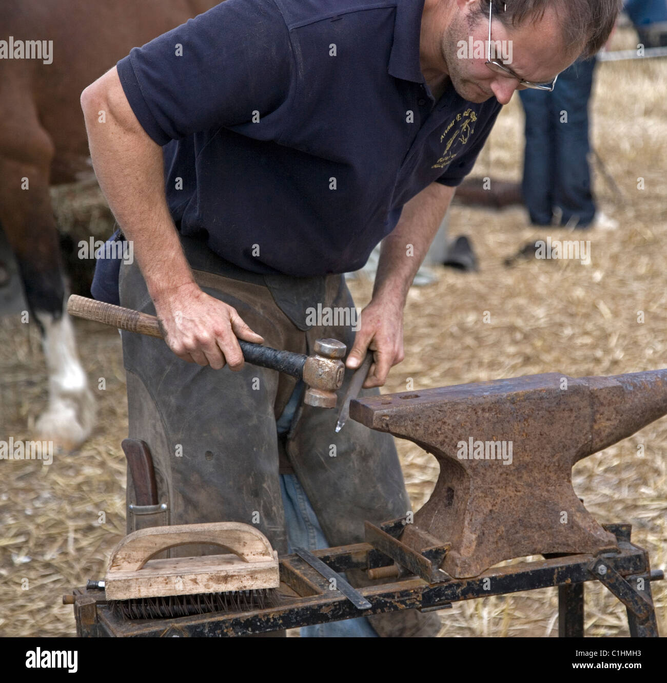 blacksmith farrier making horse shoes on an anvil at Cornwall horse and country show Stock Photo