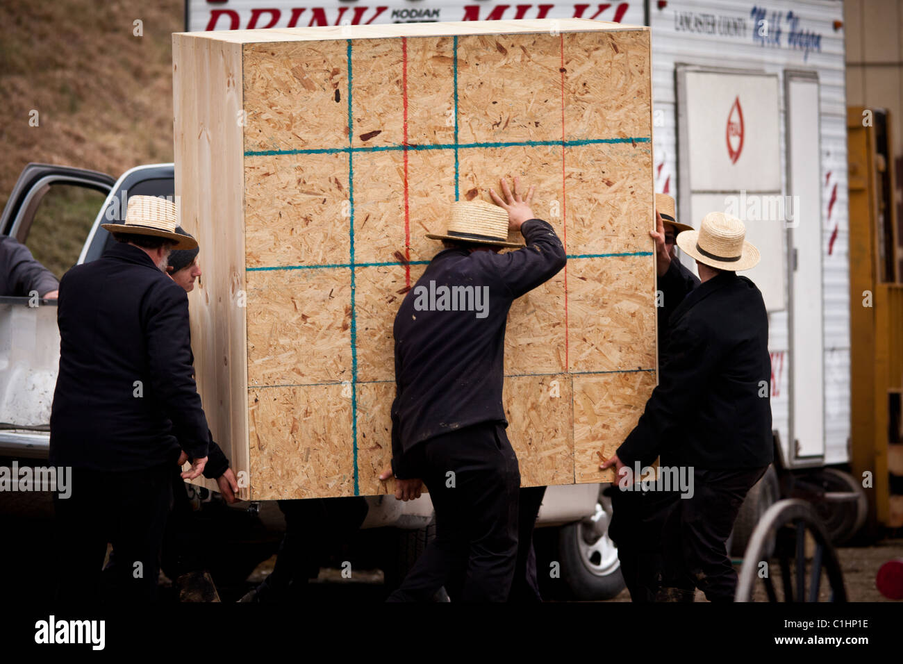 Amish men unload furniture during the Annual Mud Sale to support the