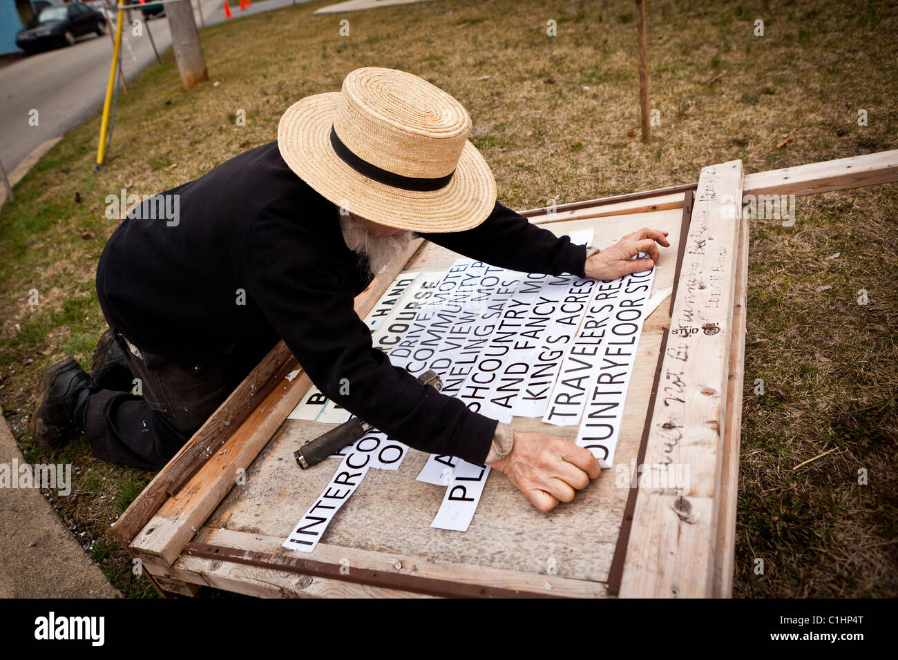 Amish man works on a sign during the Annual Mud Sale to support the Fire Department in Gordonville, PA. Stock Photo