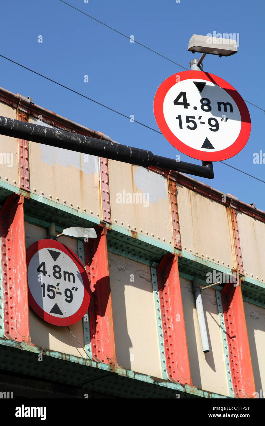 UK. HEIGHT LIMIT SIGNS ON A RAIL BRIDGE IN LONDON Stock Photo