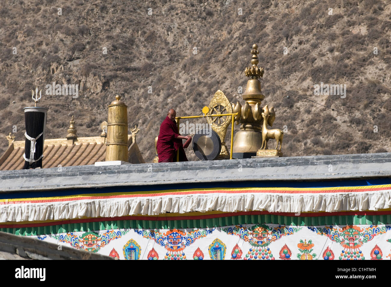 A head monk hits the big bell calling for all the monks for a prayer