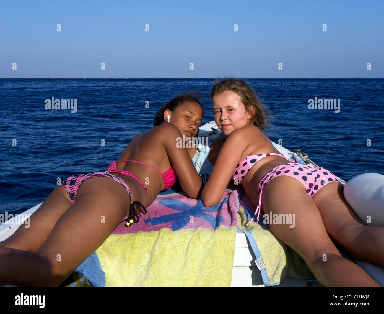 https://c8.alamy.com/comp/C1HWJ6/two-teenage-girls-lying-on-a-boat-C1HWJ6.jpg