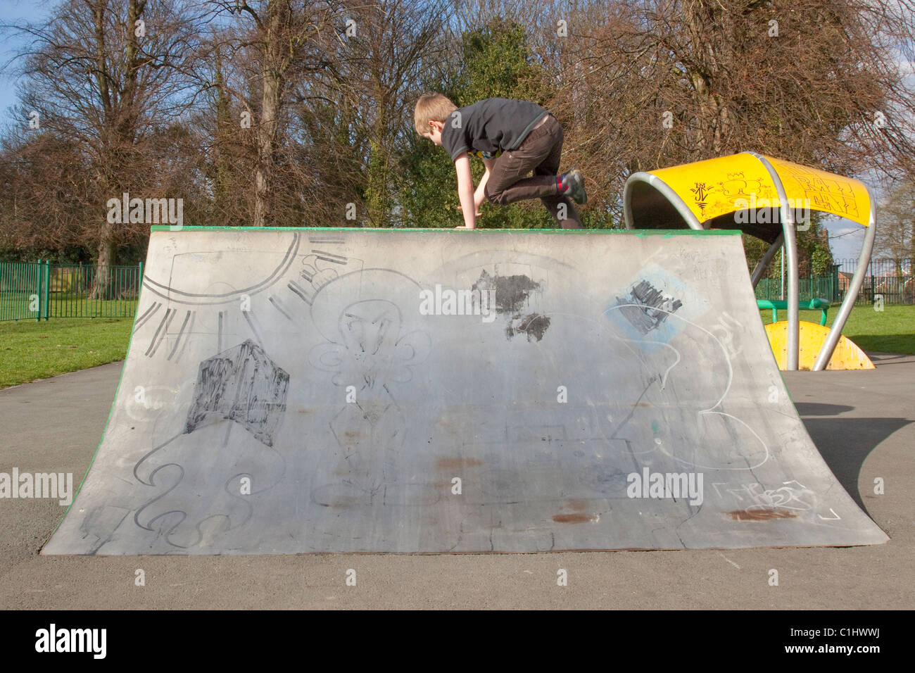 Young boy wearing safety equipment on a skateboard at a skate park