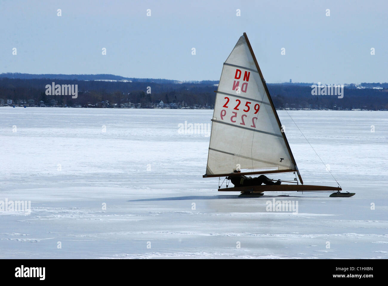 Iceboat sails across frozen Finger Lake. Stock Photo