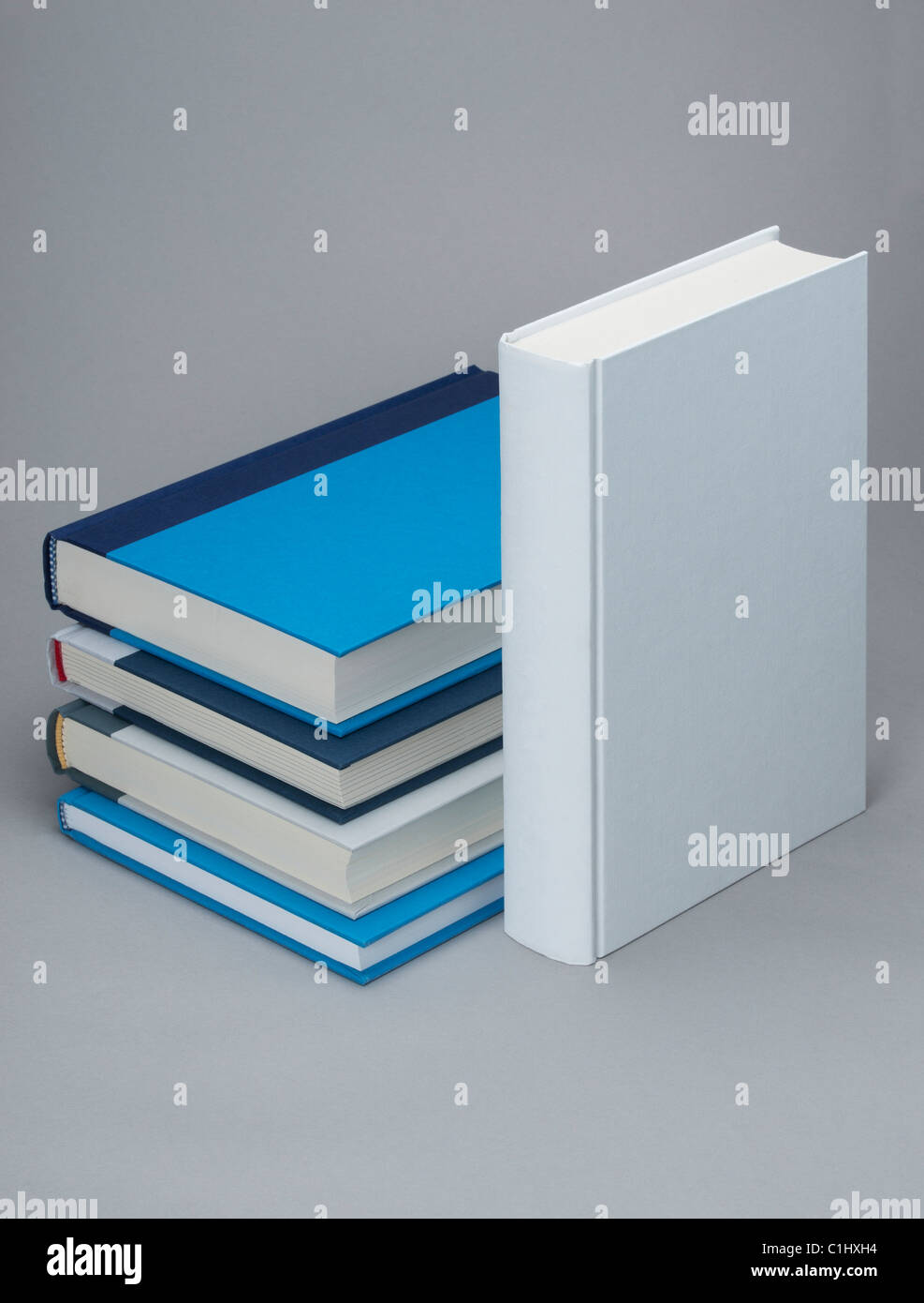 White standing book by a stack of others coloured books Stock Photo