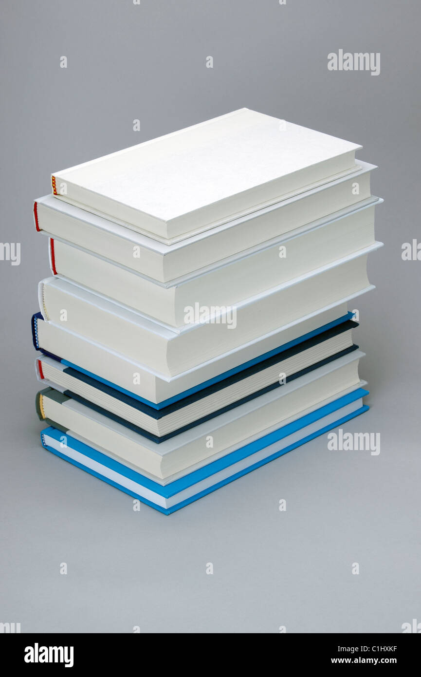 Stack of books with a white, plain book on the top Stock Photo