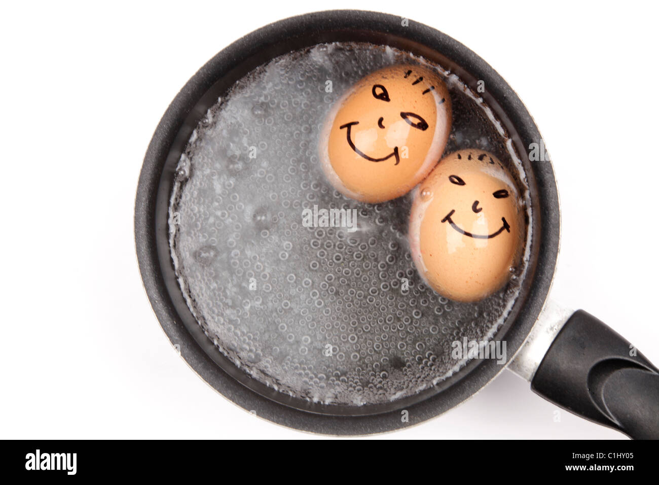 Two boiled eggs with happy faces boiling in a pan Stock Photo - Alamy