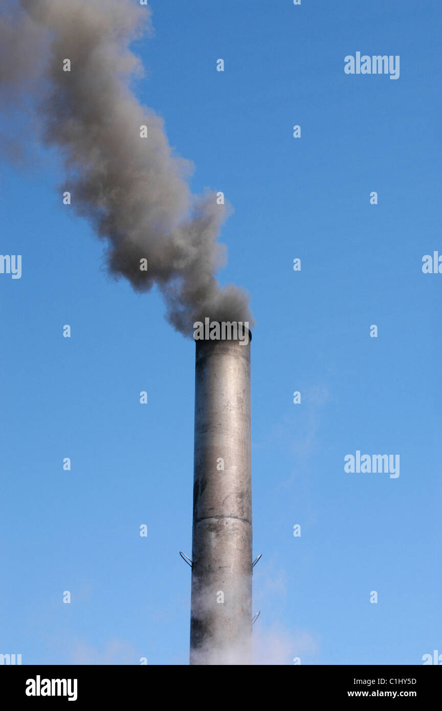 Metal traction engine chimney producing black smoke against a blue sky