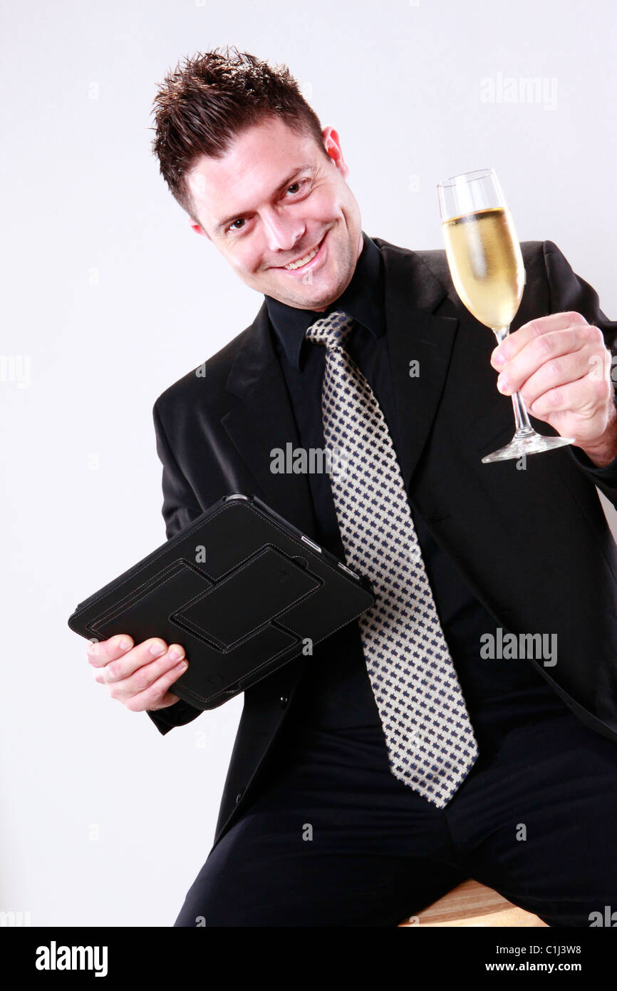 Businessman cheers with his tablet pad in one hand Stock Photo
