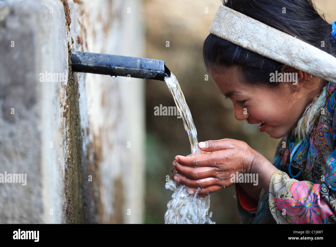 Nepali girl drinking water in Nepal Stock Photo Alamy