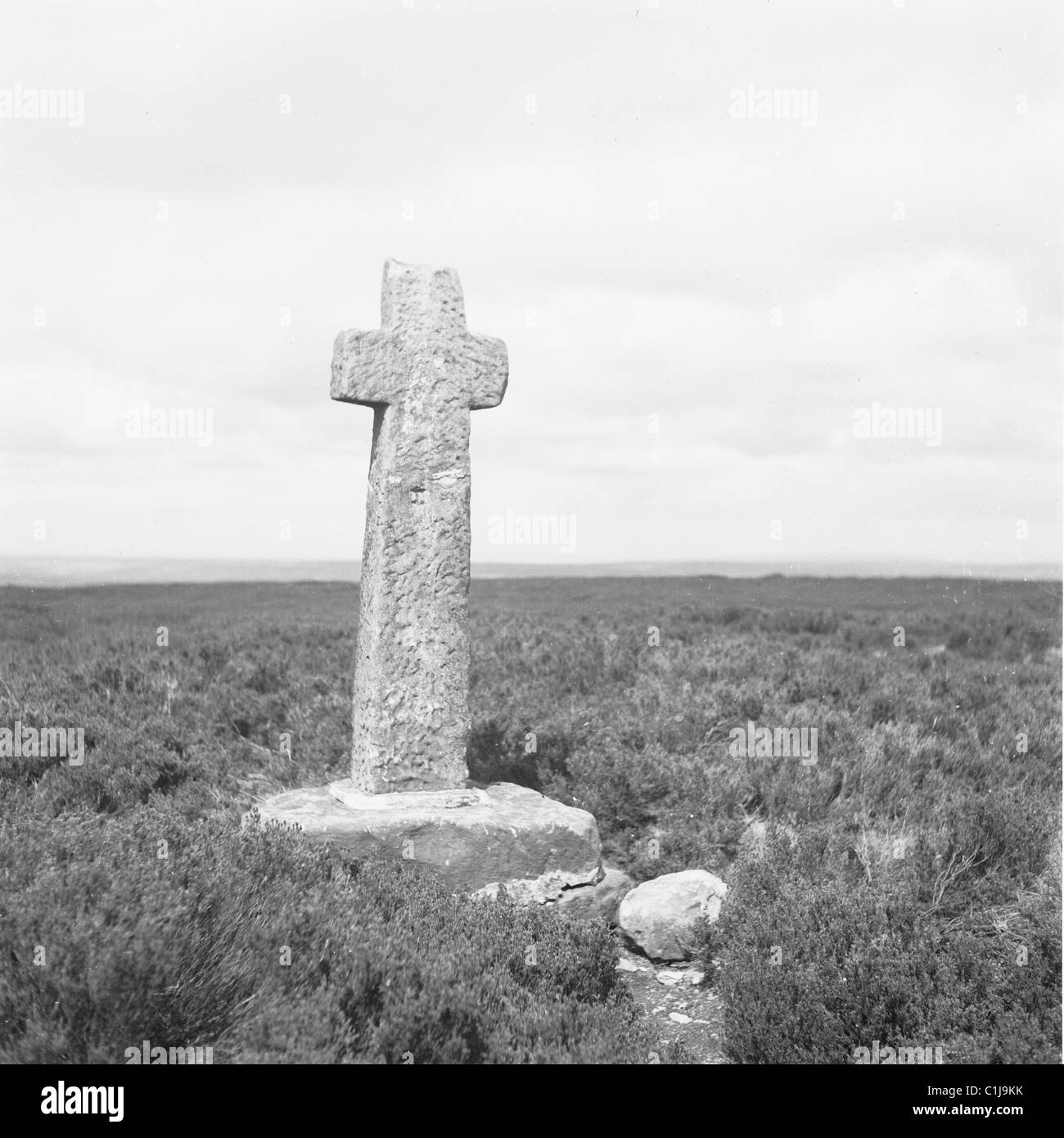 1950s, a small stone cross in field, Portugal. Ancient christian monuments, why they are there is often a mystery, possibly to do with atonement. Stock Photo