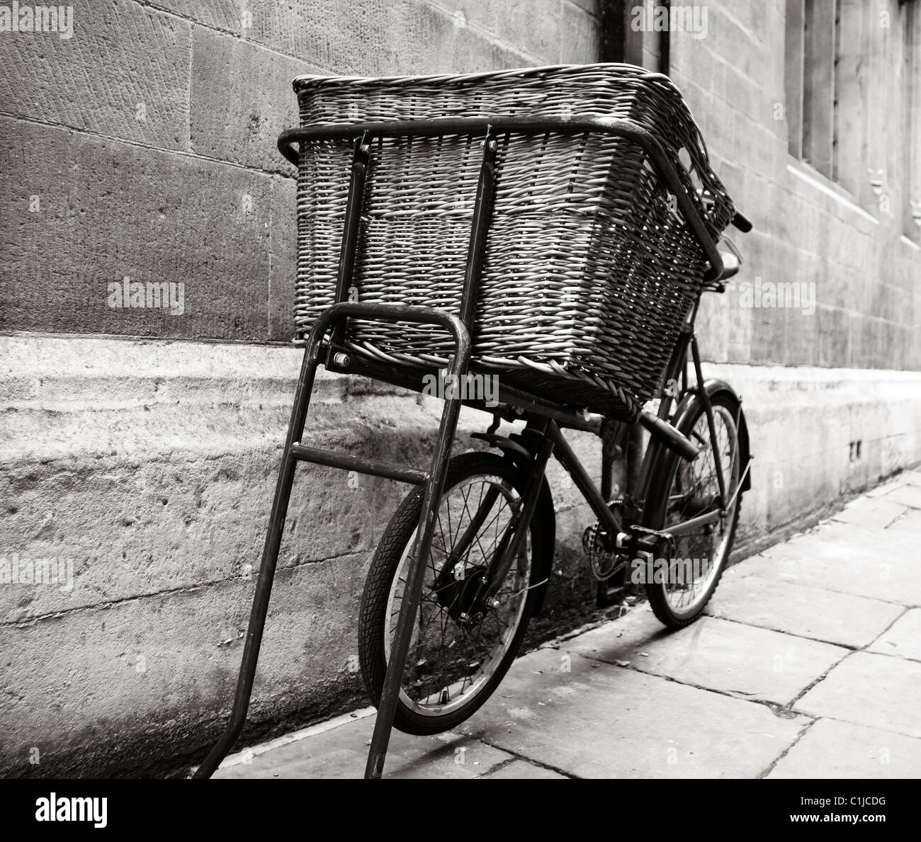 Old Bicycle in Black and white with large delivery basket in the city