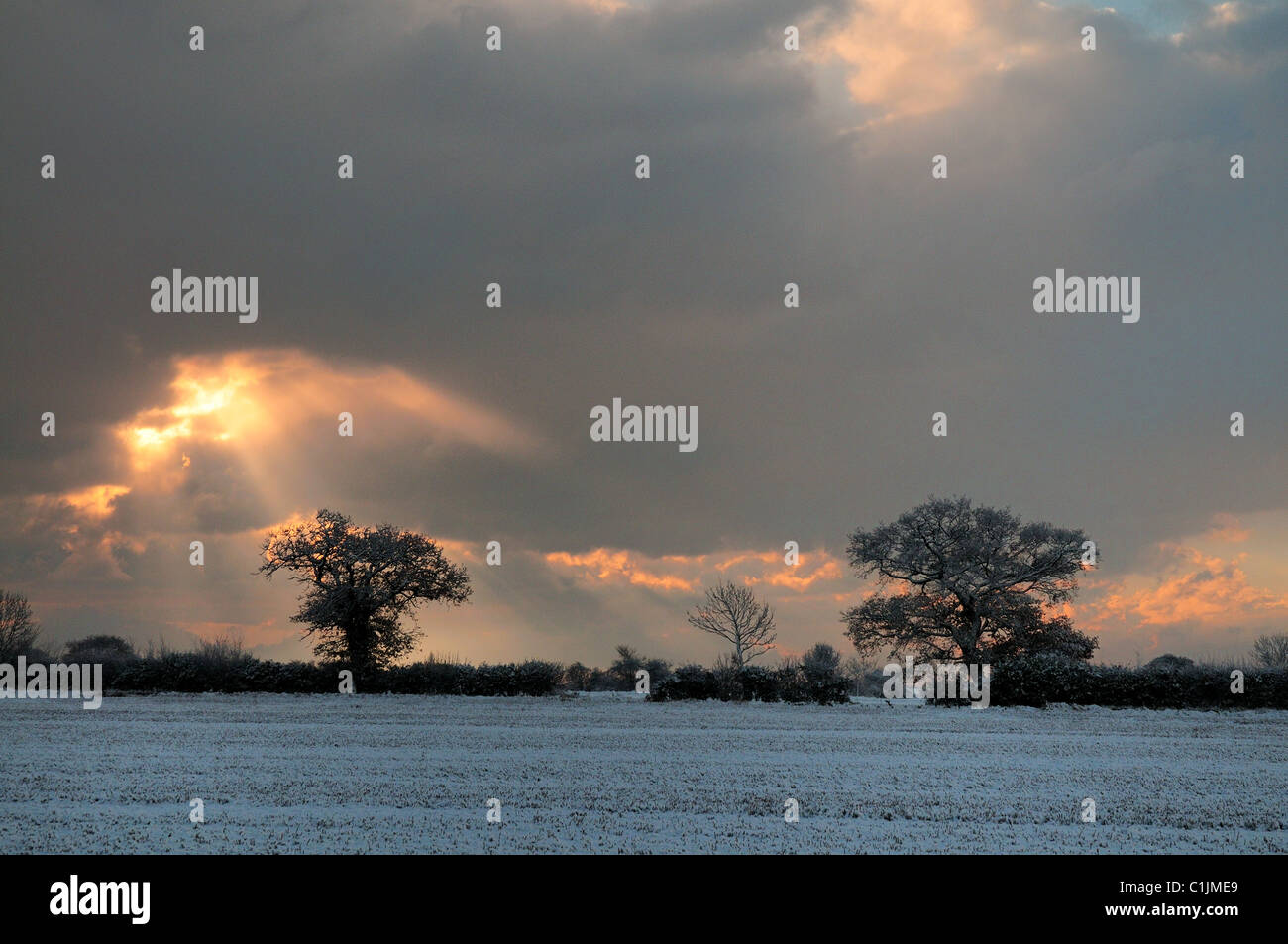 Moody Skies & Sunbeams, Tunstall Suffolk following first snow fall as Autumn turns to Winter. November 2010 Stock Photo