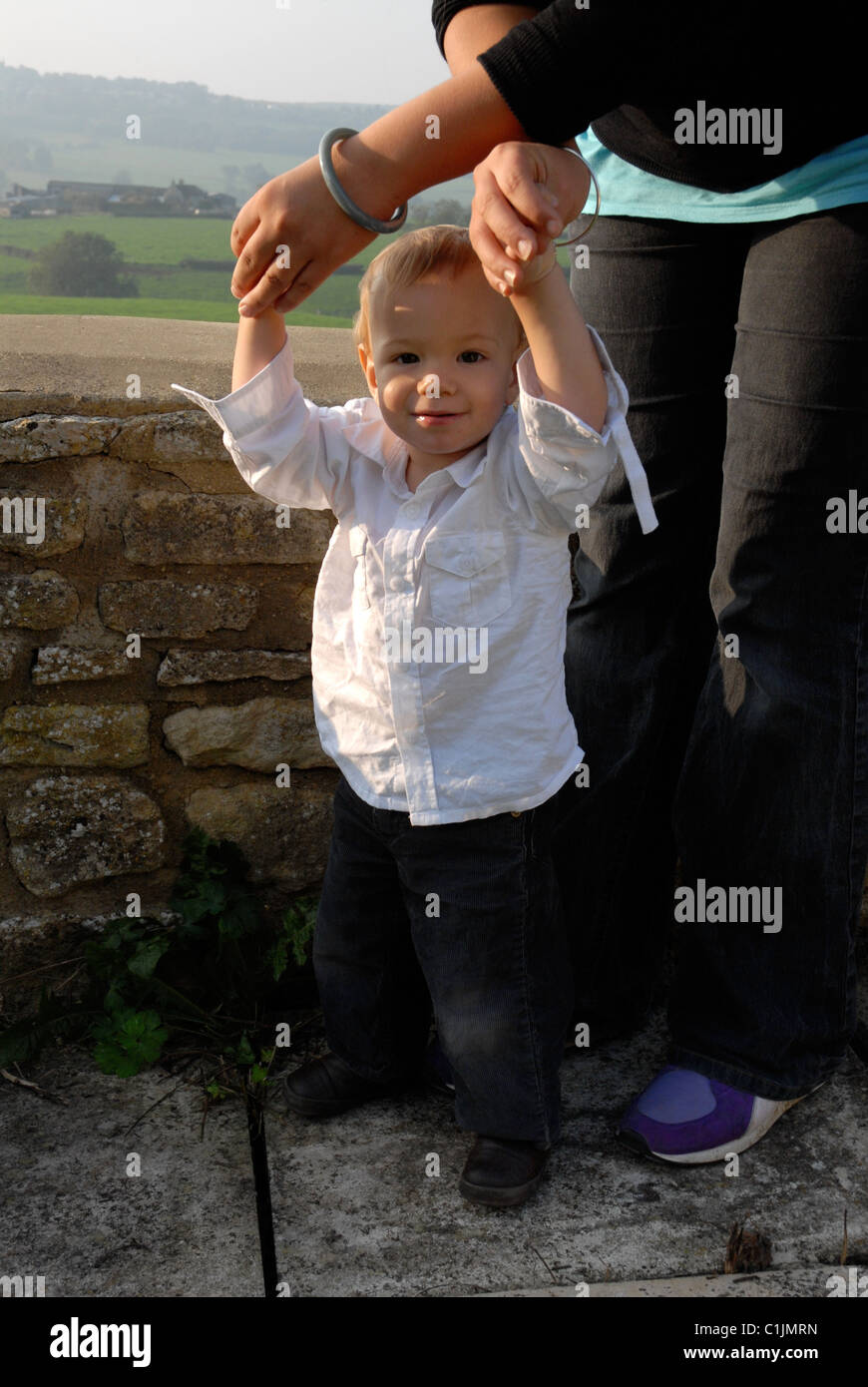 Toddler learning to walk, being helped by his mother Stock Photo - Alamy
