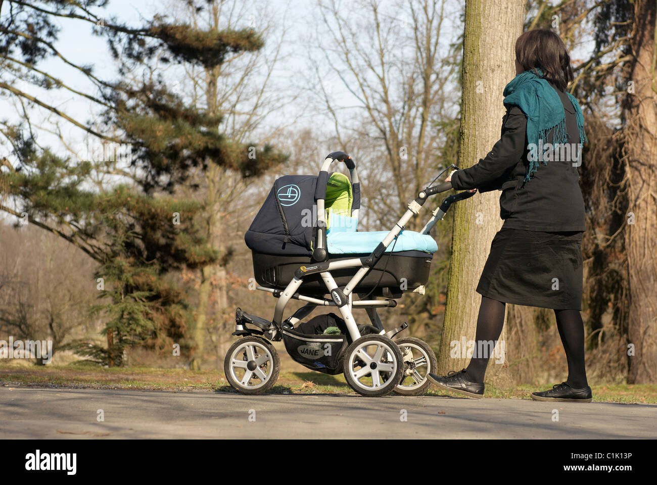 A woman mother pushing pram with child baby walking in the Park, spring  Stock Photo - Alamy