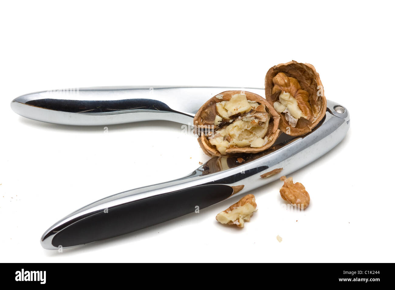 Cracking walnuts with nutcracker over white background Stock Photo Alamy