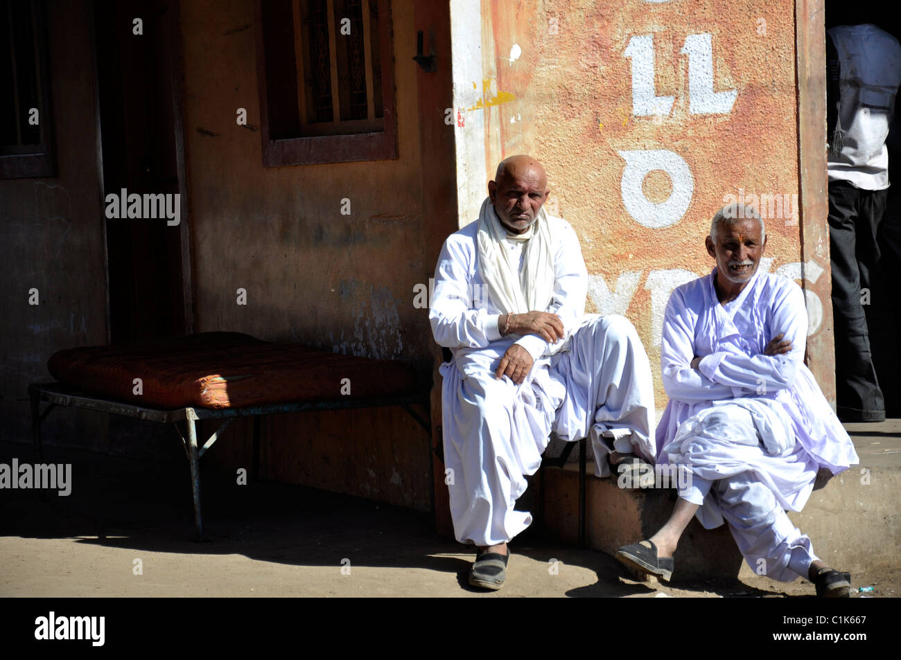 Two old Indian wearing traditional dress, sitting out side in winter season Stock Photo