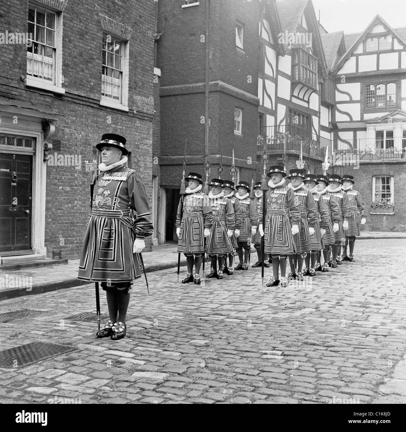 1950s, the Chief warden of the Tower of London leads a parade of yeoman or wardens of the English Royal guard, Tower Green, London, England. Stock Photo