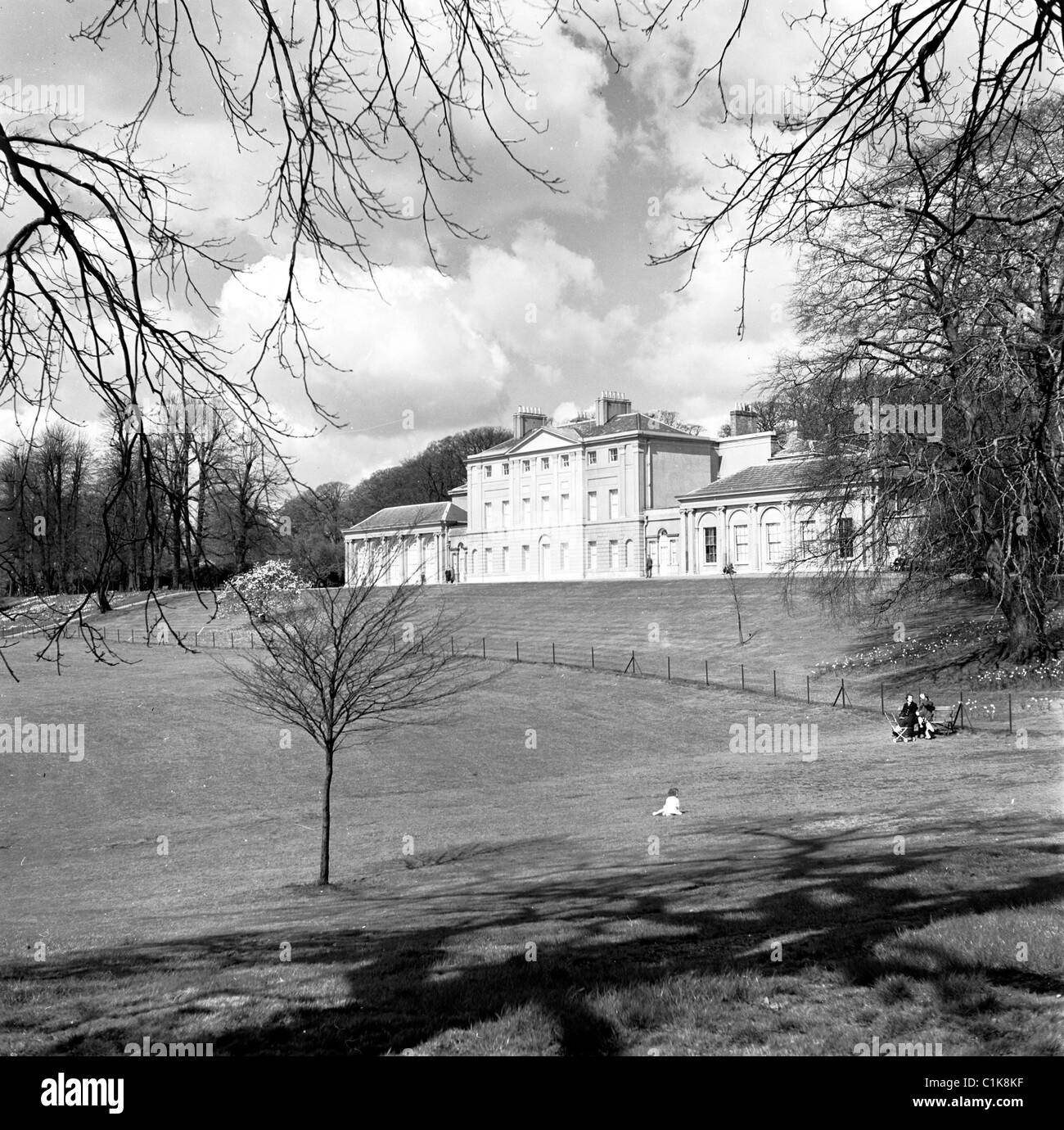 1950s, two women sit on a bench with a pram in the grounds of Kenwood House at Hampstead Heath, the former residence of the Earls of Mansfield. Stock Photo
